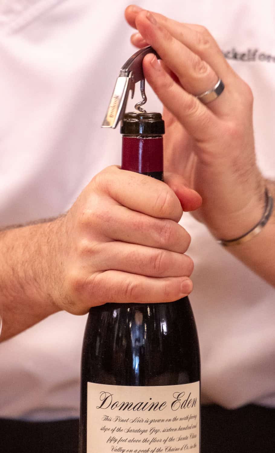 Using an opener on a bottle of Pinot Noir