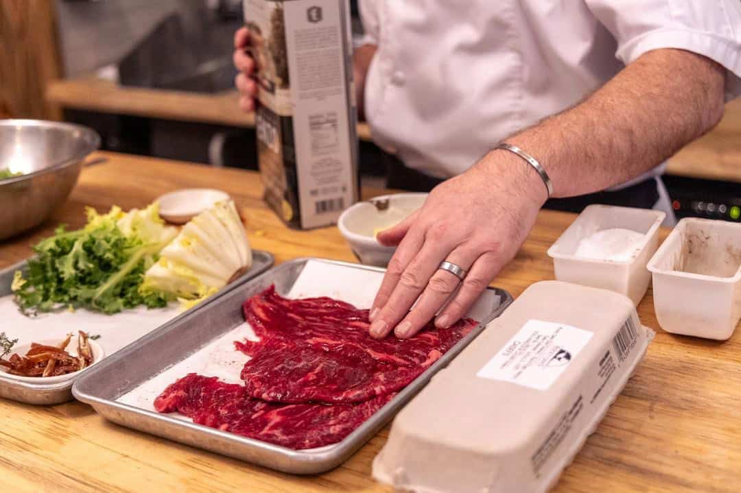 Chris Shackelford marinating the steak to make Beef Tagliata