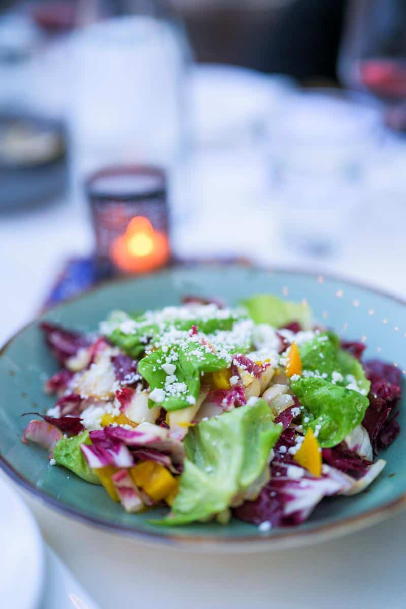 green and purple salad leaves in a blue bowl