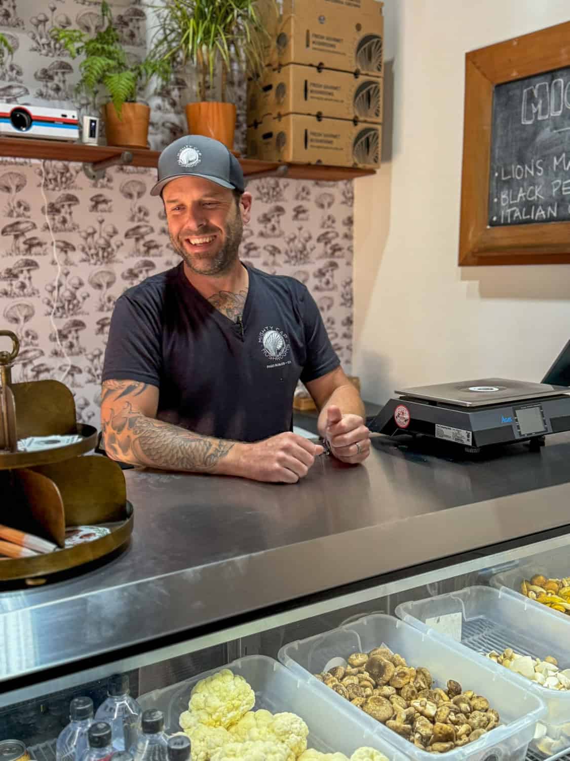 man at counter inside Mighty Cap Mushrooms