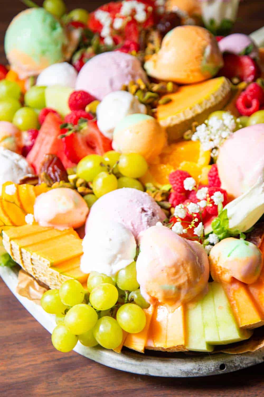 A cmelon and summer fruit platter with scoops of sherbert