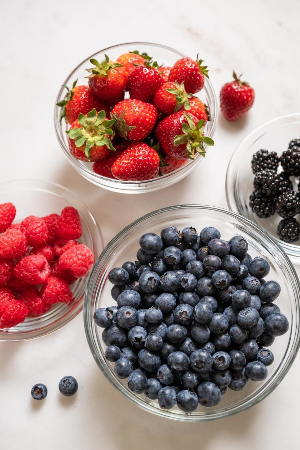 strawberries, blueberries and raspberries in bowl