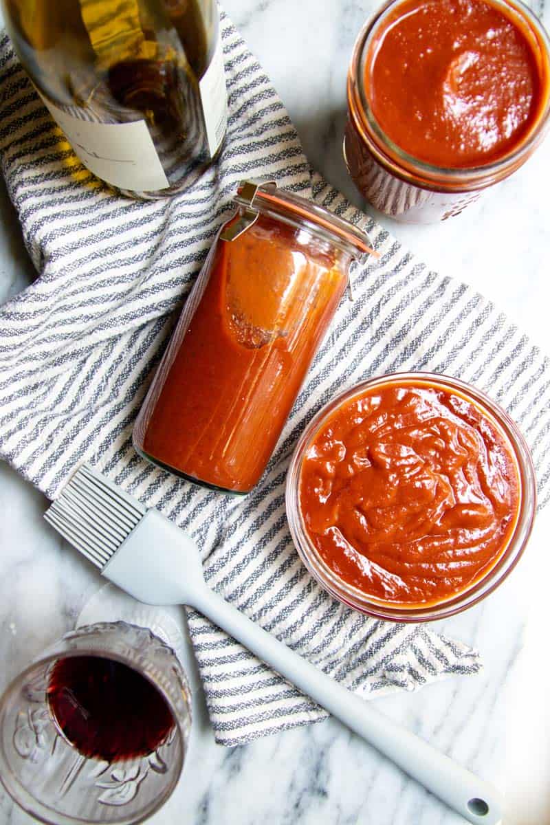 Red wine barbeque sauce in a few jars and a bowl.