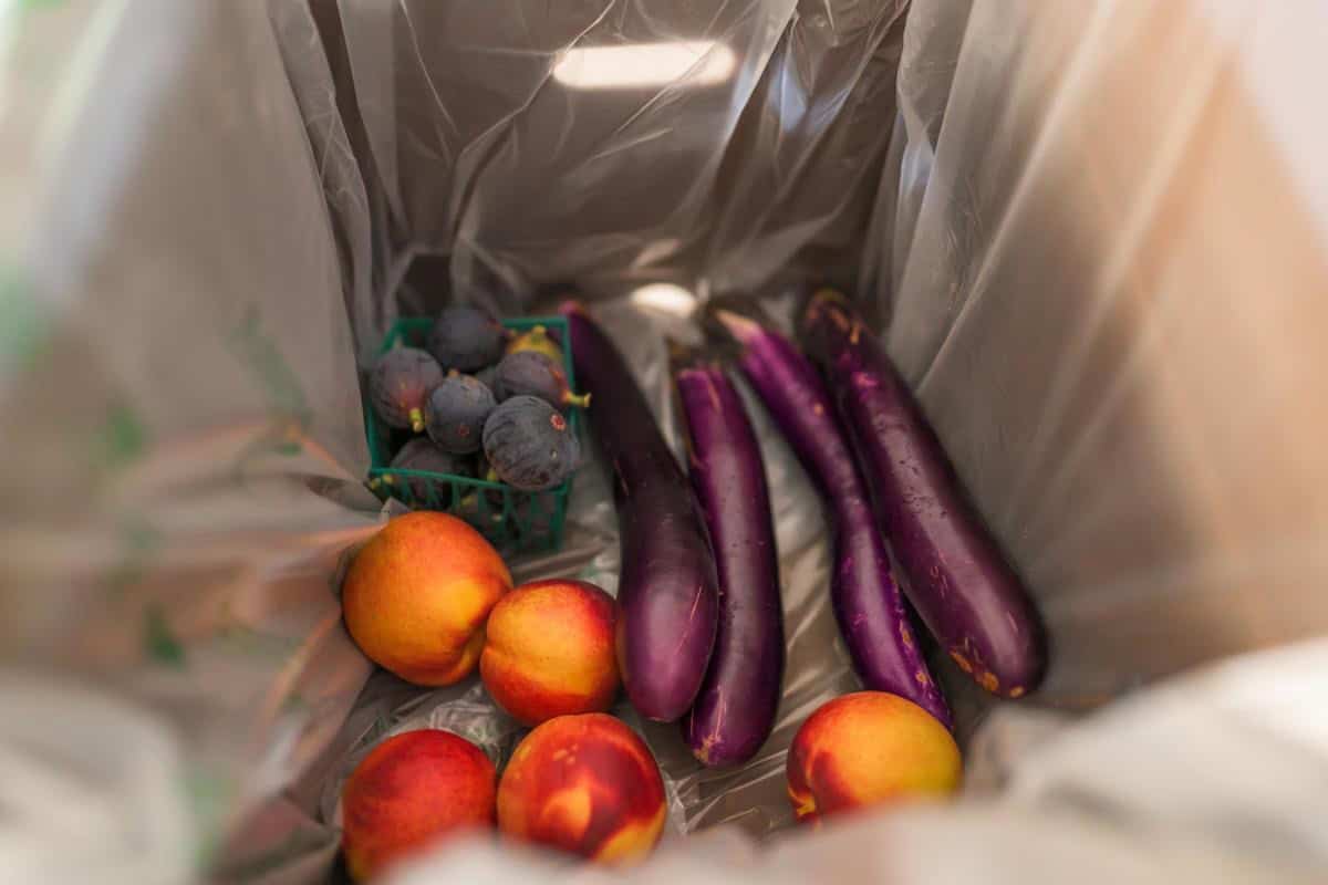 produce box with eggplants, figs and peaches