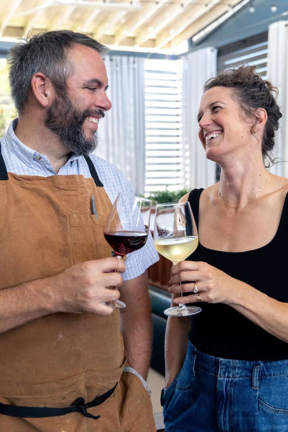 Brad and Mackenzie Cecchi toasting with glasses of wine