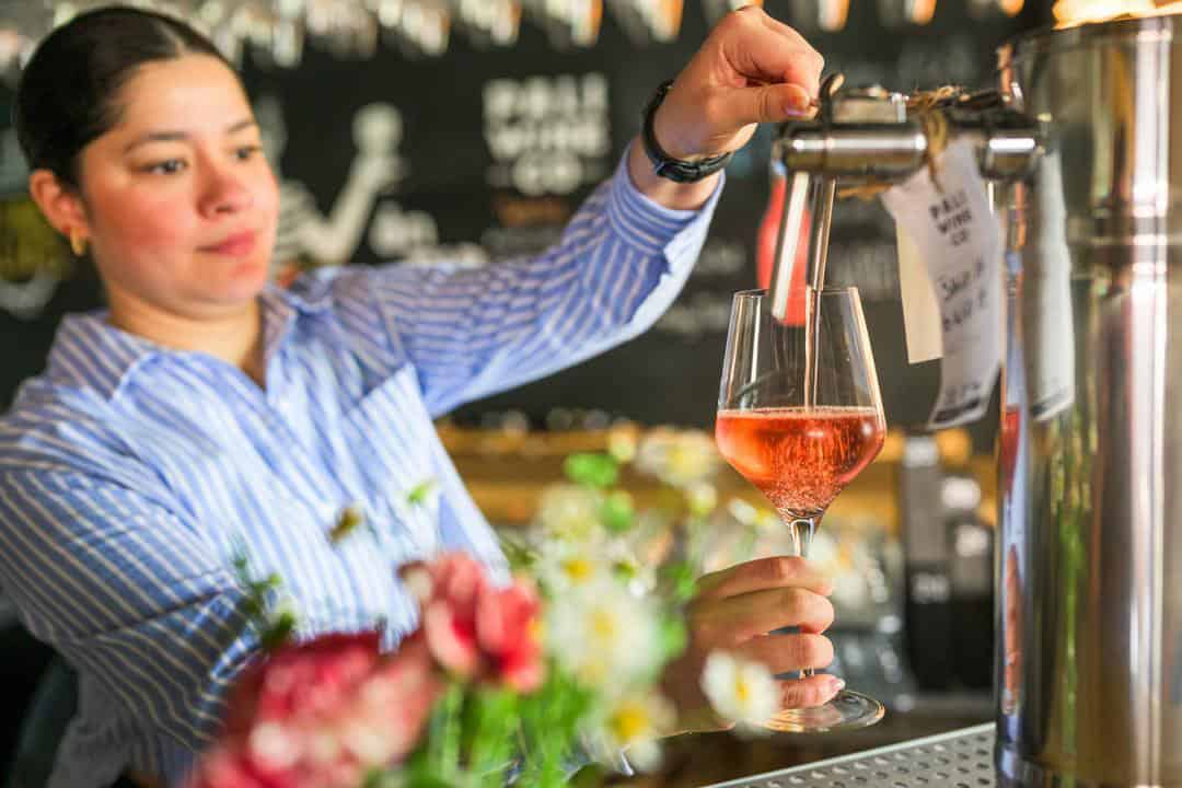 Mia Murillo pouring a glass of rose at Pali Wine Co. 