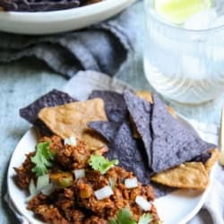 A plate of turkey picadillo and colorful tortilla chips.