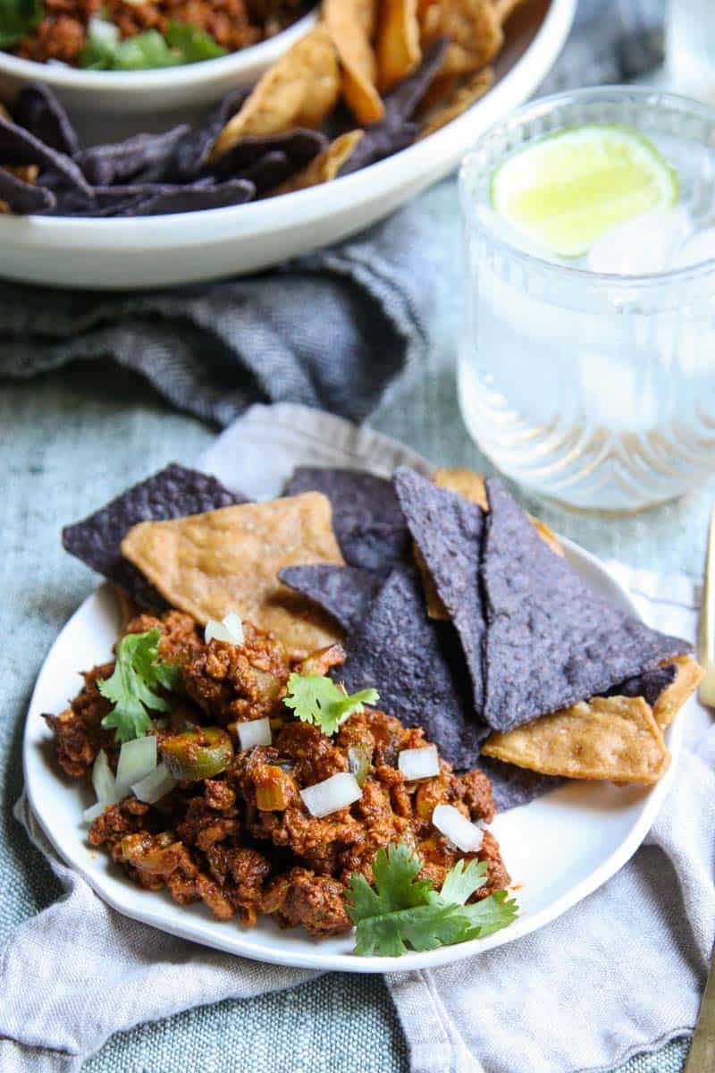 A plate of turkey picadillo and colorful tortilla chips.