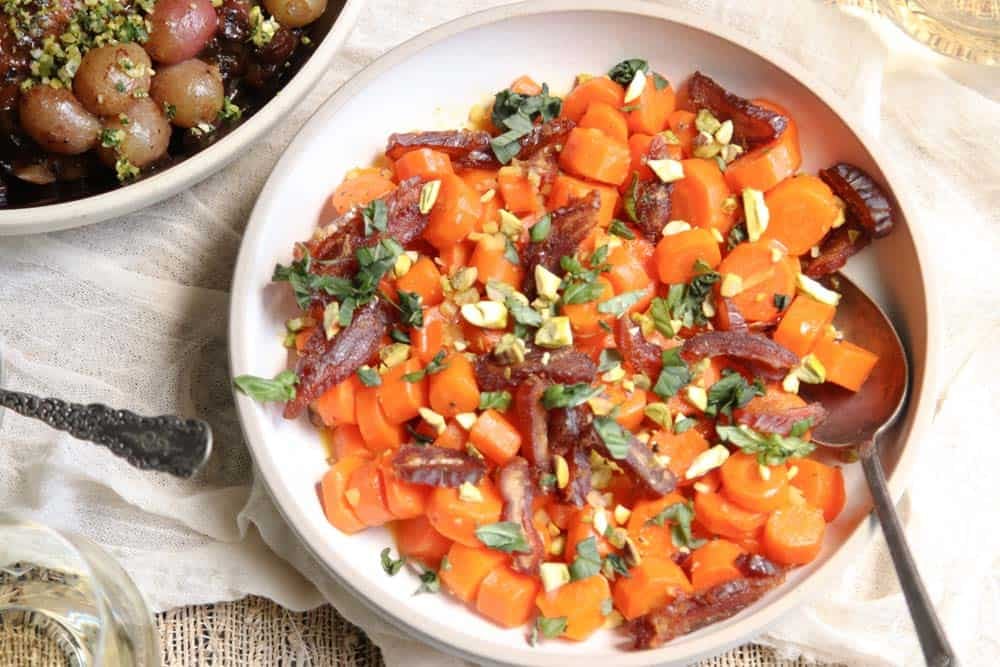 A table set for dining with our easy Honey Butter-Glazed Carrot recipe and a chicken dish.