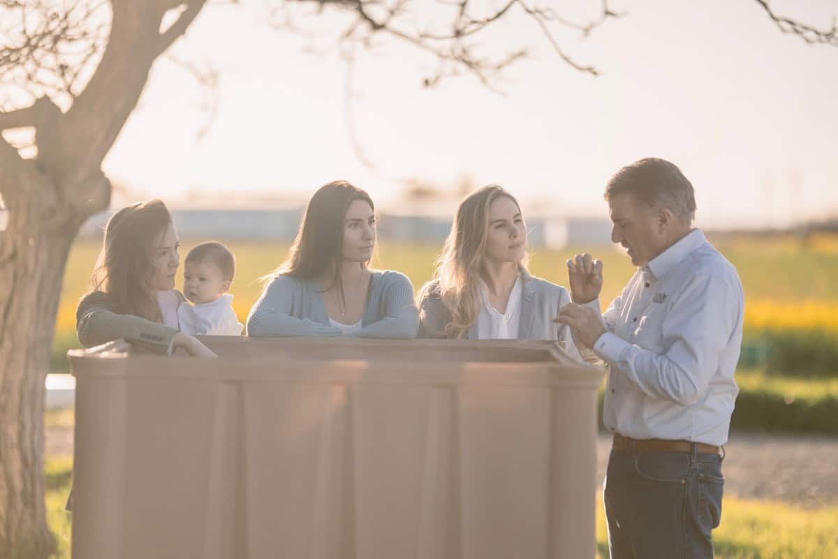 Taylor sisters looking at their father over a bin of prunes