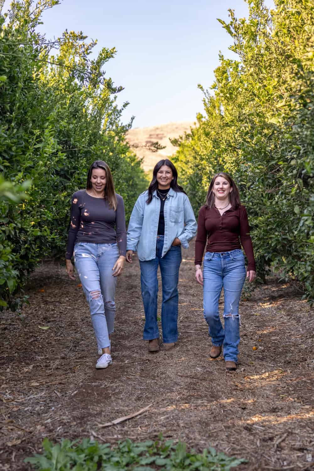 Jenna, Bea and Elise walking through the family orchard