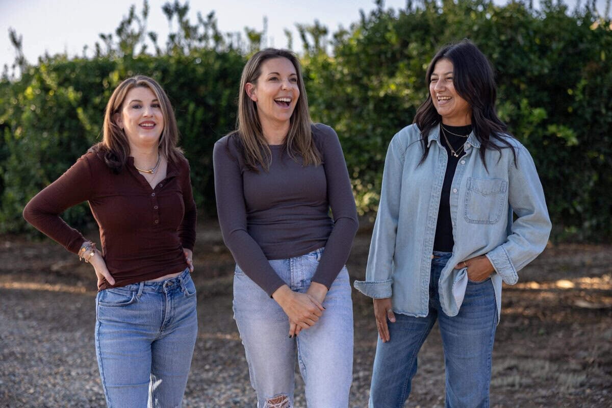 Elise, Jenna and Bea laughing in their family's orchard