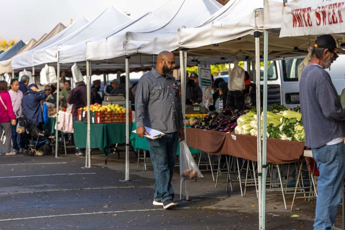 Dennis Sydnor perusing the farmers market for produce he'll use at Empress Tavern