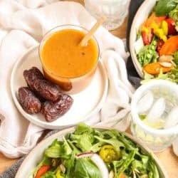 A small jar of date vinaigrette on a plate with whole dates.