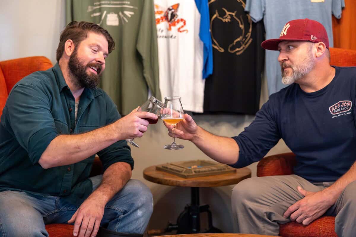 Two men enjoying drinks at Posterity Ciderworks