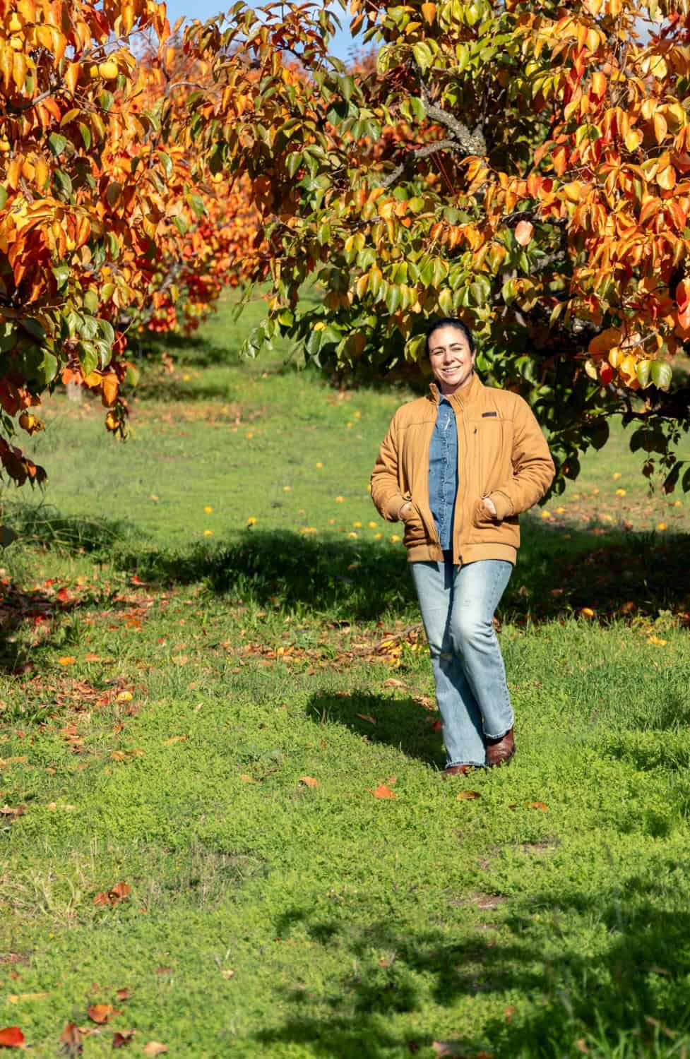 Camelia Enriquez walking through the persimmon orchards at Twin Peaks Orchards