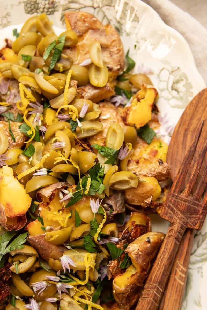 a platter of potatoes topped with olives