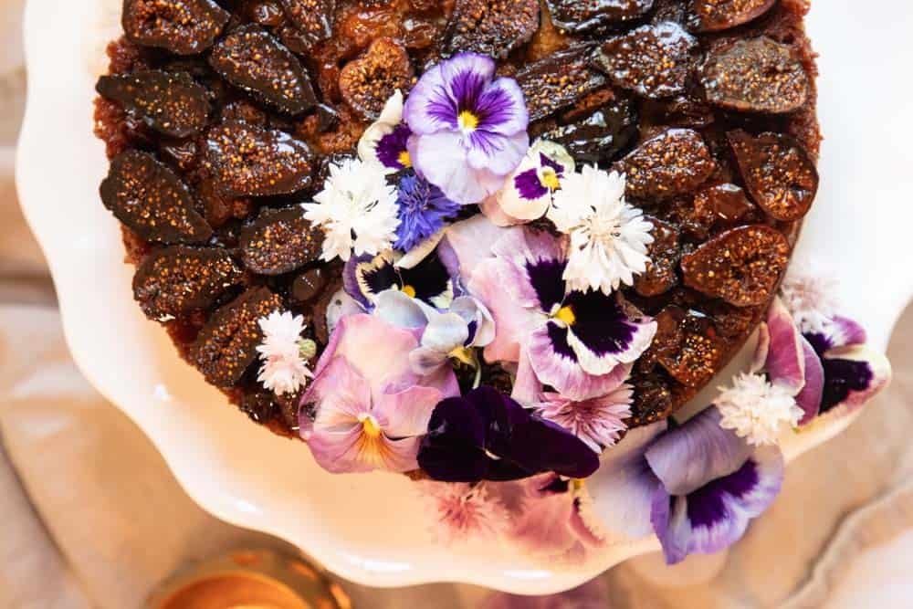 Close up of edible flower detail on dried fig cake.