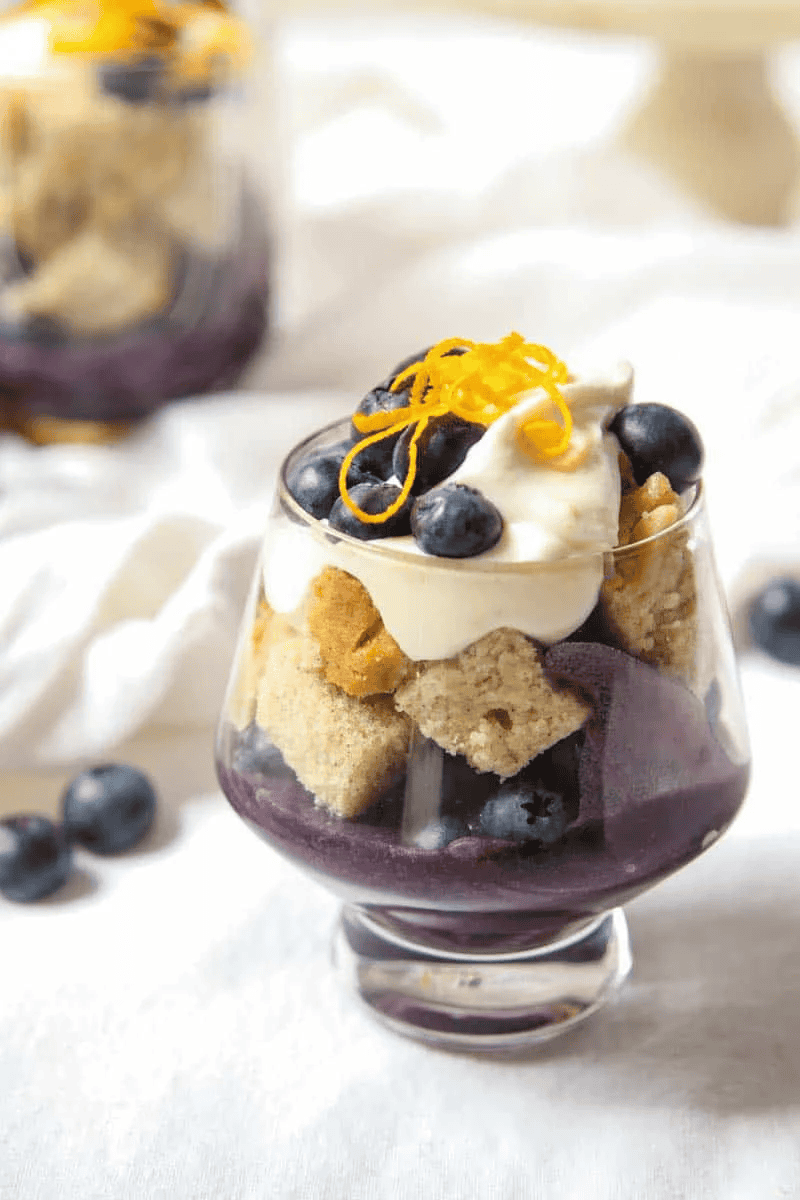 blueberry curd in a glass with cake and cream