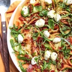 A large platter with a Cantaloupe and Prosciutto Salad ready to serve.