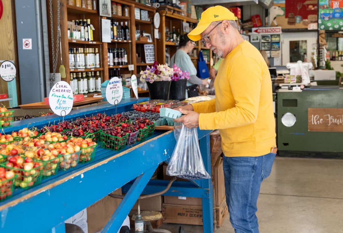 man shopping for produce at the Fruit Bowl