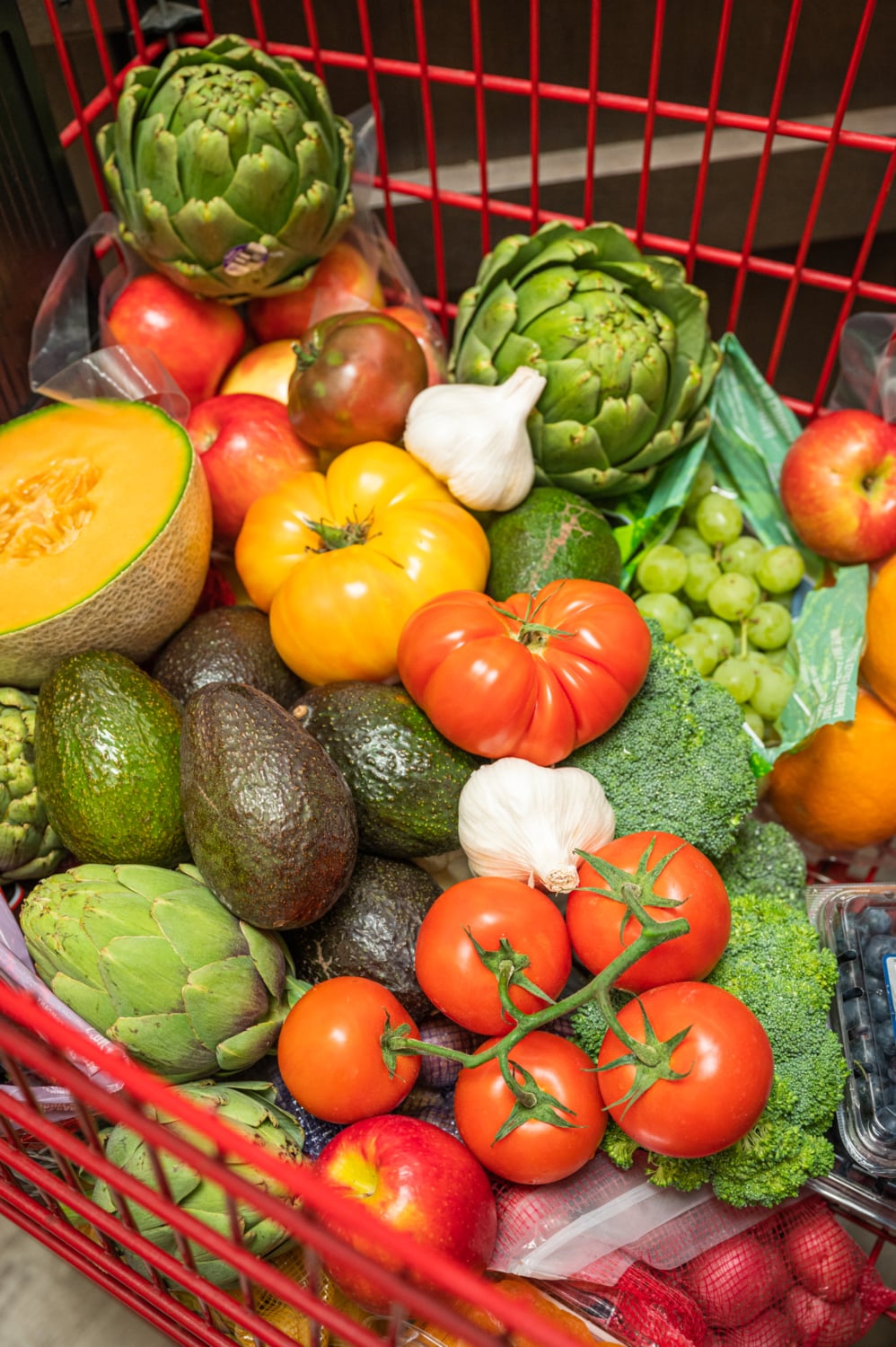avocados and other produce in a shopping cart