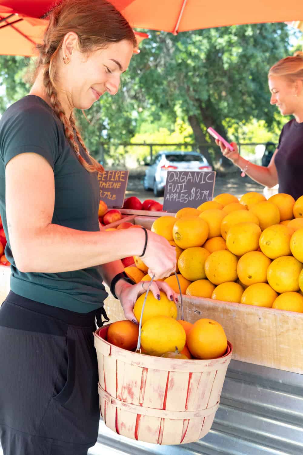 woman holding a basket full of citrus