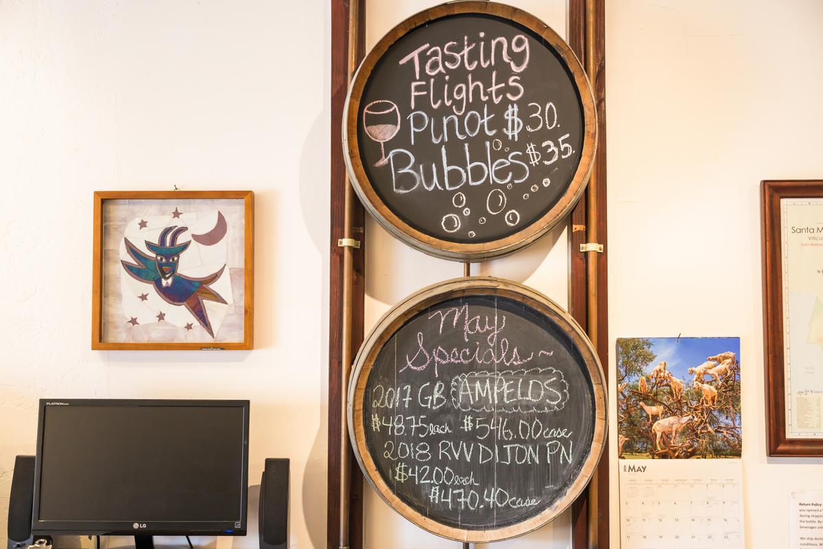 chalk boards on wall that depict which types of wines are available for wine tasting
