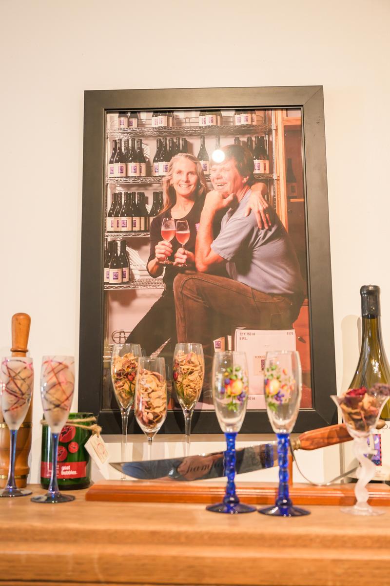 portrait of a man and a woman behind a counter at a wine tasting room