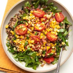 Close up of corn salad with wild rice and tomato.