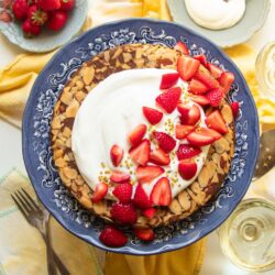 An almond cake made with date sugar and topped with unsweetened whipped cream and fresh strawberries.