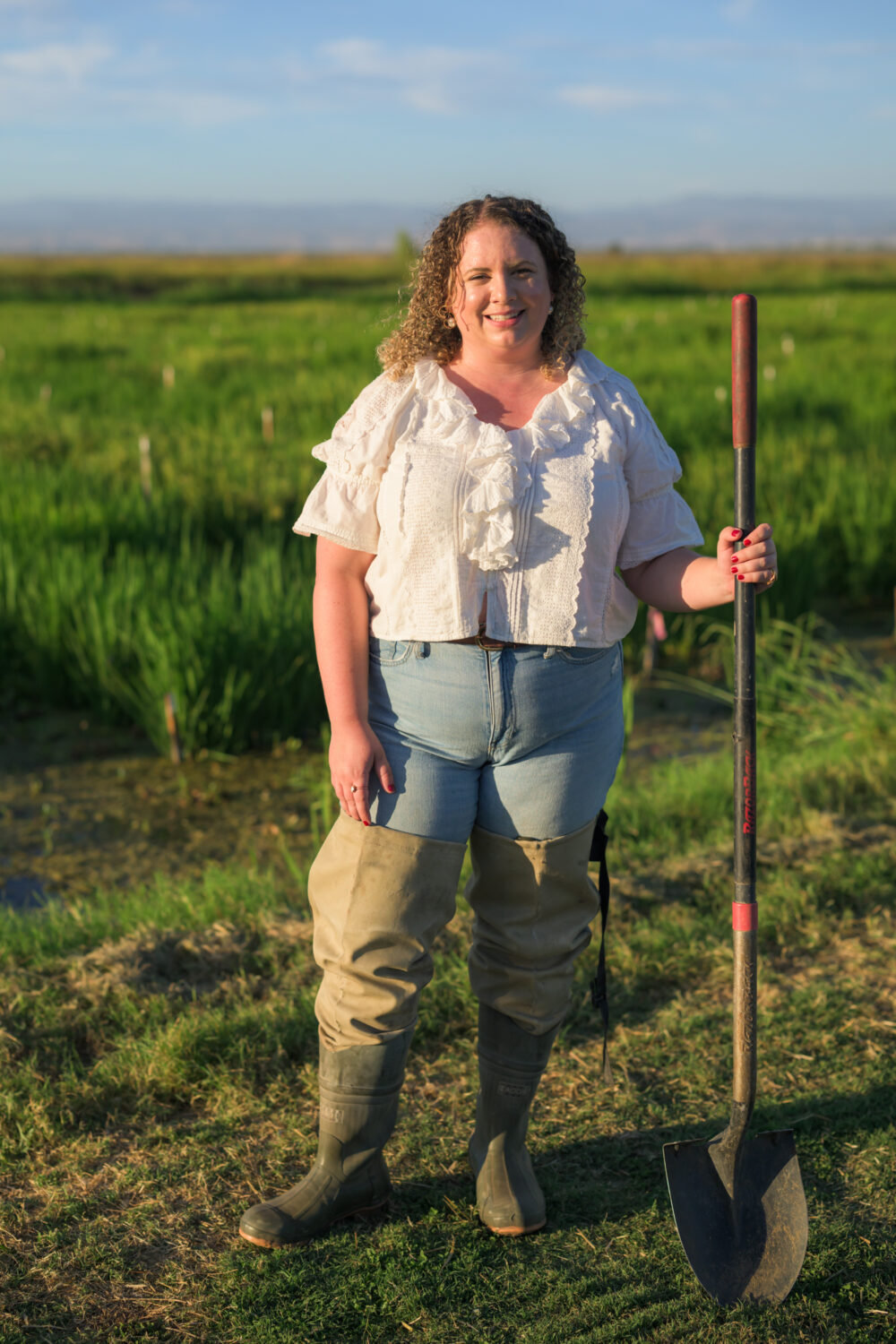 Brita Lundberg standing on the edge of a rice field at Lundberg Family Farms