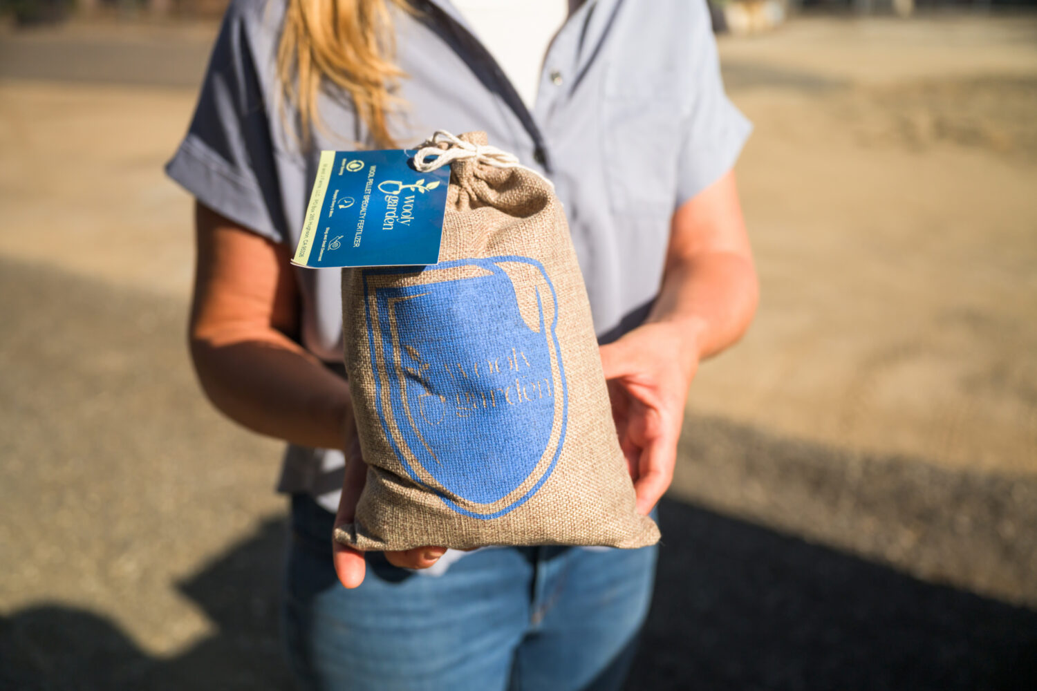 Marcie holding a bag of M&J Farms fertilizer